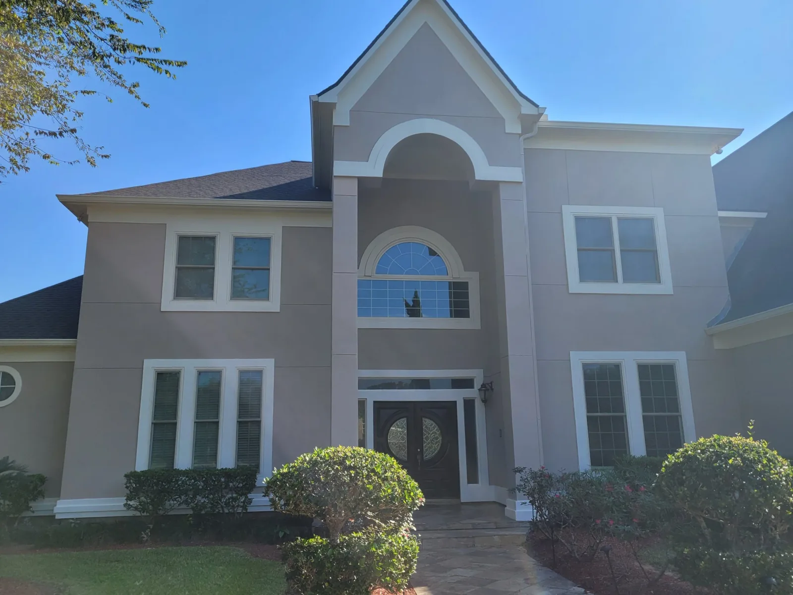 Detailed full exterior repaint of a two-story home in Sugar Land by The Proud Paintbrush