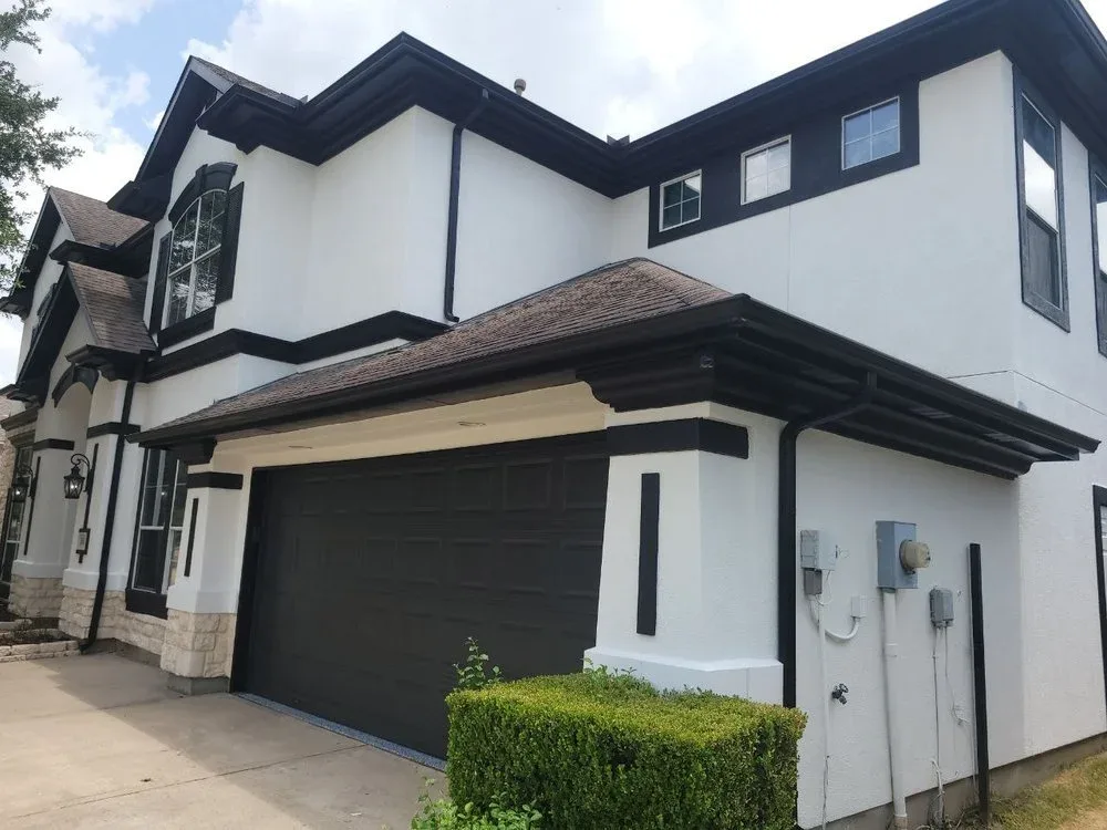 Freshly painted crisp white and black two-story stucco home in Sugar Land by The Proud Paintbrush