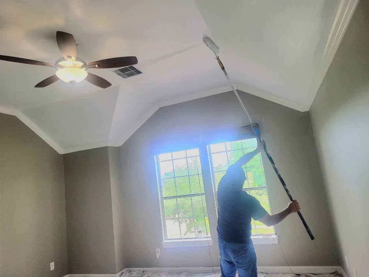 Painter rolling a freshly painted ceiling in Missouri City, TX