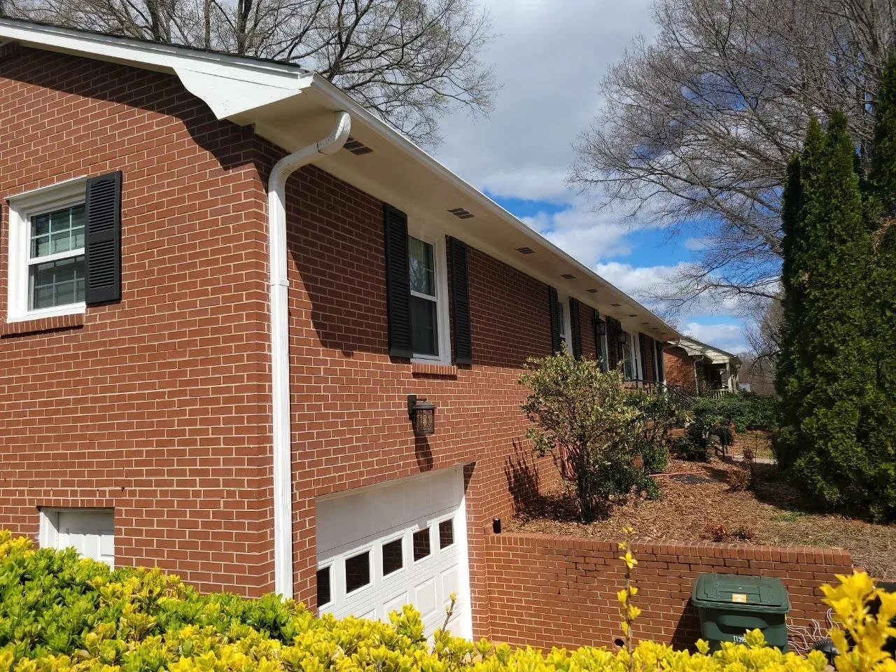 Red brick home with black shutters in Southwest Houston, TX by The Proud Paintbrush