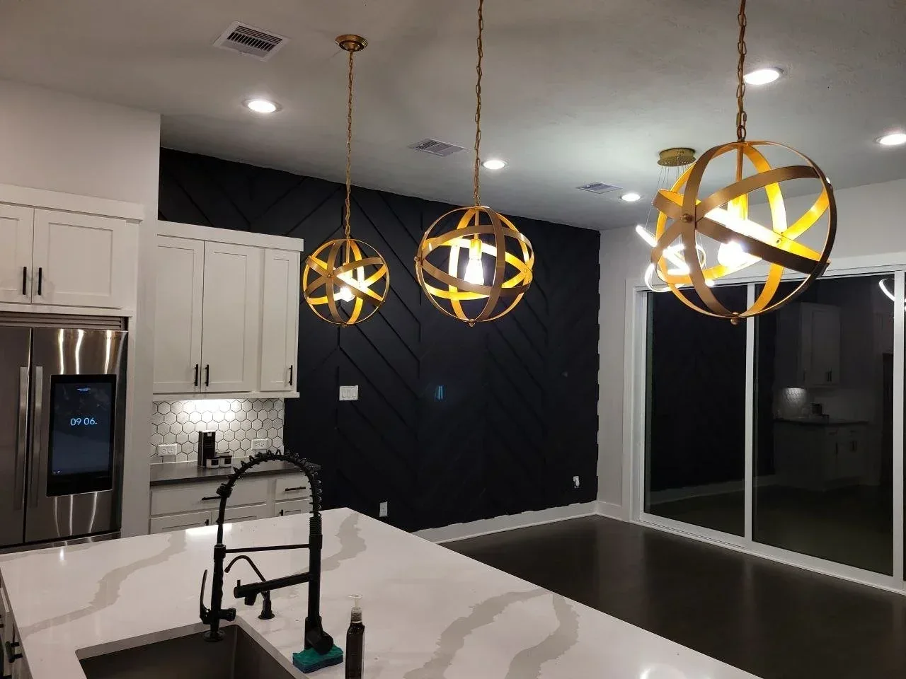 Dining area with a black accent wall and statement lighting in Richmond, TX by The Proud Paintbrush