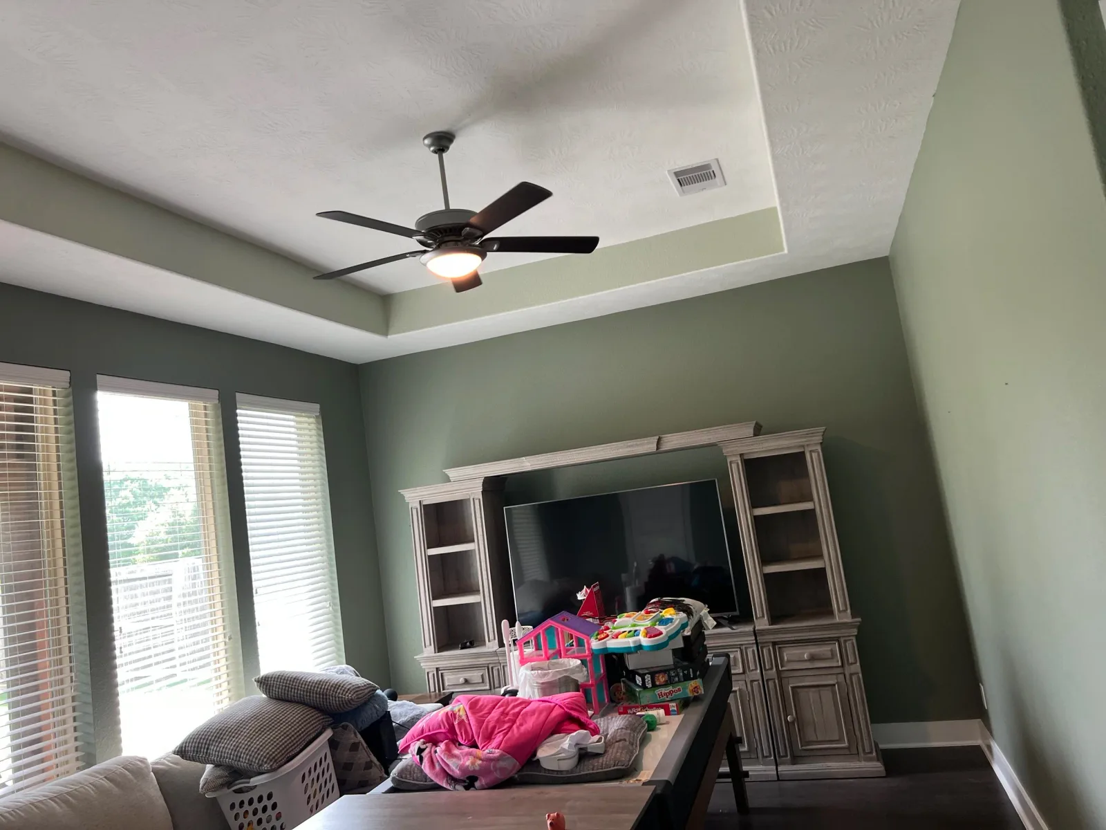 Bedroom with a soft green monochromatic palette in Sugar Land, TX by The Proud Paintbrush