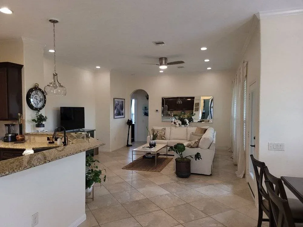 Freshly painted open-concept kitchen and living room with warm neutral colors in Sugar Land, TX by The Proud Paintbrush