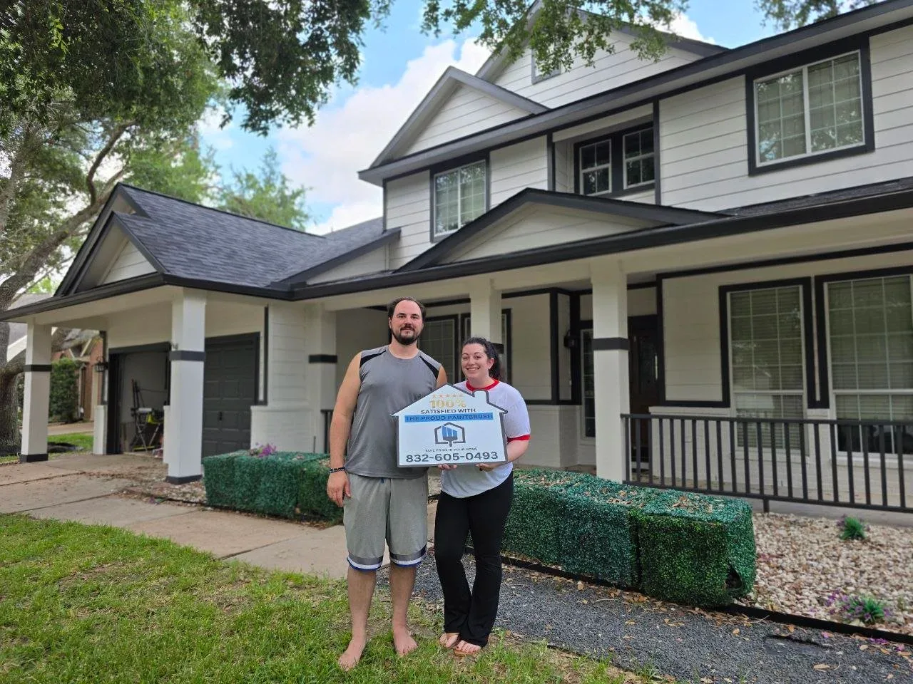 Satisfied homeowner in front of a freshly painted white and black exterior in Missouri City, Texas